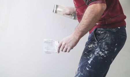 Worker grinding wall with sandpaper. Renovation