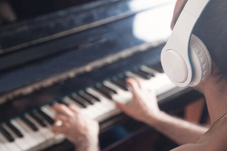 Musician with headphones playing on piano.の写真素材