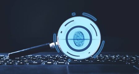 Magnifier with fingerprint on laptop keyboard. Personal information securityの写真素材