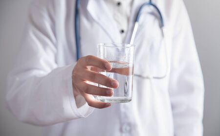 Medical doctor holds glass of water.の写真素材