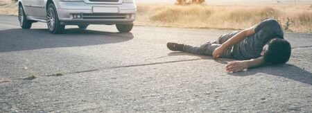 Caucasian injured man lying on asphalt.の写真素材