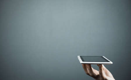 Male hand holding white digital tablet.の写真素材