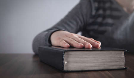 Girl with Holy Bible in the wooden table.の写真素材