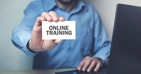 Man showing Online Training text on business card.の写真素材