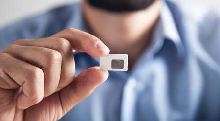 Male hand holding Sim card.
