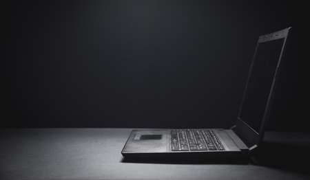 Black laptop on the black office desk. Technology conceptの写真素材