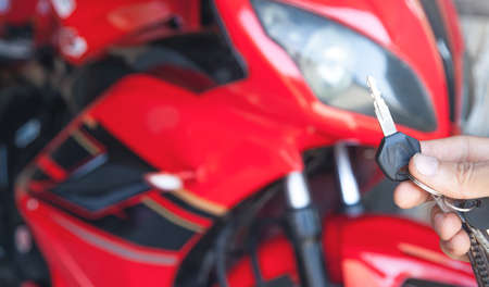 Hand holding a keys in the garage, on the background of motorcycle.の写真素材