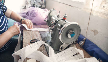 Caucasian seamstress working with sewing machine.