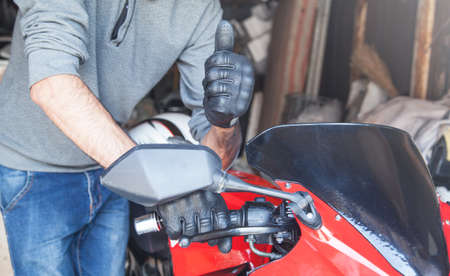Young caucasian motorcyclist giving thumbs up.の写真素材