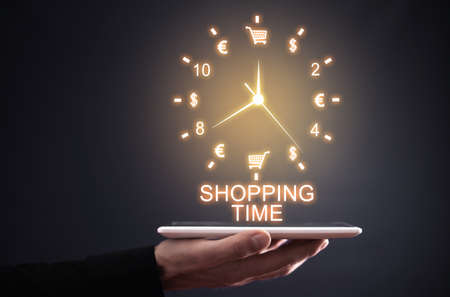Male hand holding clock. Shopping time. Online shoppingの写真素材