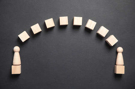 Wooden human figures with cubes on the black background.の写真素材