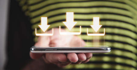 Man holding smartphone with download icon.の写真素材