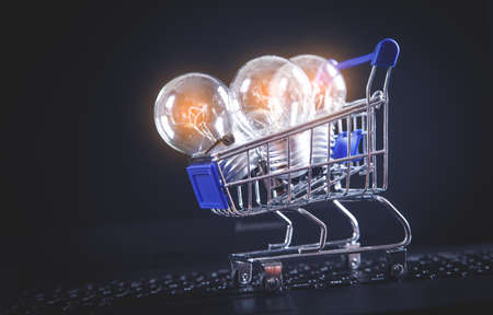 Light bulbs with shopping cart on computer keyboard.の写真素材