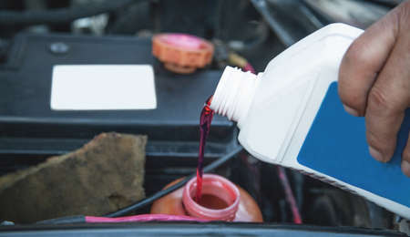 Pouring motor oil into the engine.の写真素材