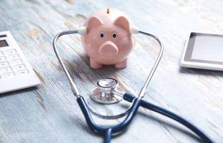 Piggy bank with stethoscope on the desk.の写真素材