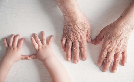 Elderly woman and a kid hands together.の写真素材