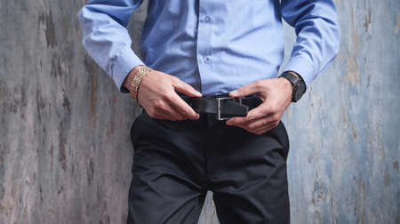 Businessman correcting his belt. Fashion, Lifestyle