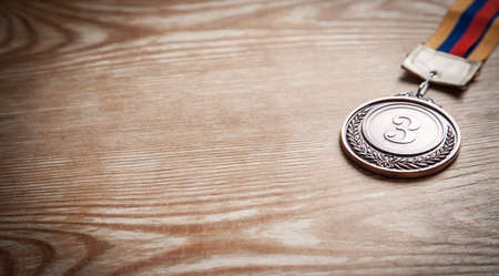 Medal awards for winner on wooden background.