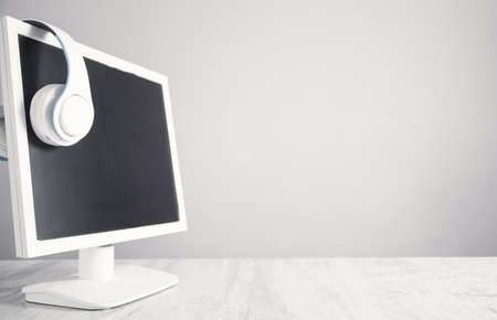 White headphones with a computer monitor.の写真素材