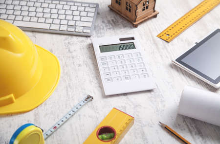 Wooden house model with a helmet and tablet.