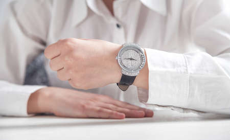 Business girl showing his wristwatch.