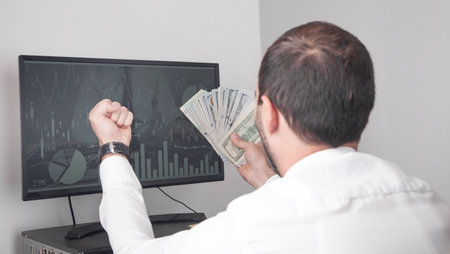 Man showing money in computer screen.