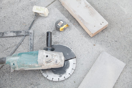 Angle grinder, stone, measuring roller on asphalt background.の写真素材