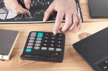 businessman using calculator. Working in financial graphs