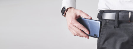 Man putting smartphone in pocket of trousers.の写真素材