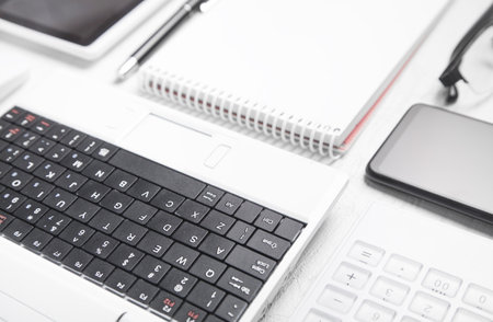 White laptop and business objects on the white desk.