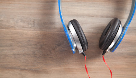 Blue headphones on the wooden background.