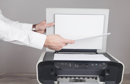Man copying and scanning documents in office.