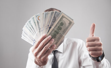 Man with dollars making thumb up.