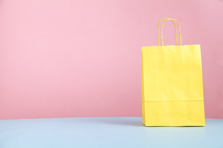Yellow shopping bag on the pink and blue background.の写真素材