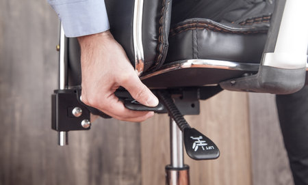 Male hand adjusts office chair.の写真素材