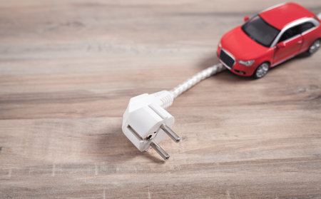 Red toy car with electrical plug. electric carの写真素材