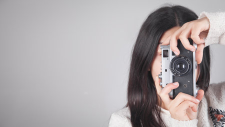 Girl holding a retro camera in office.の写真素材