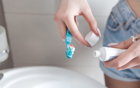 Young woman holding toothbrush before brushing teeth.の写真素材
