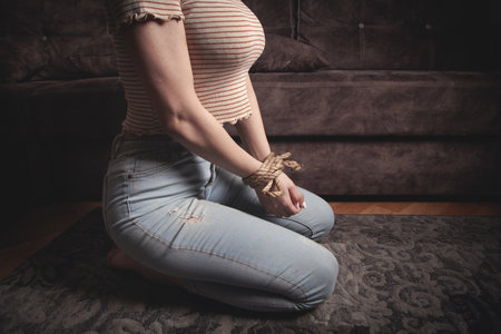 Hands of a victim woman tied with rope.の写真素材