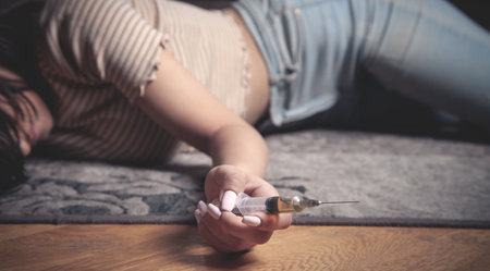 Drug addict with a syringe at home.の写真素材