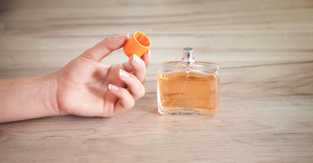 Girl hand with a bottle of perfume.