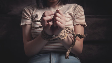 Hands of a victim woman tied with rope.の写真素材