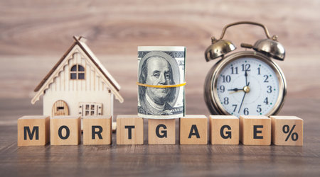 House model, money, alarm clock and word Mortgage on wooden cubes.の写真素材