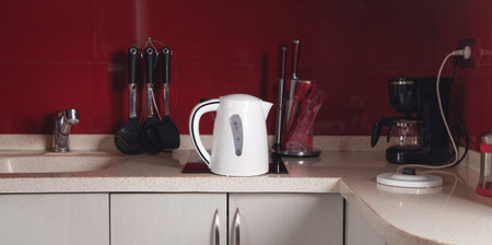 Set of cookware, white kettle in kitchen.
