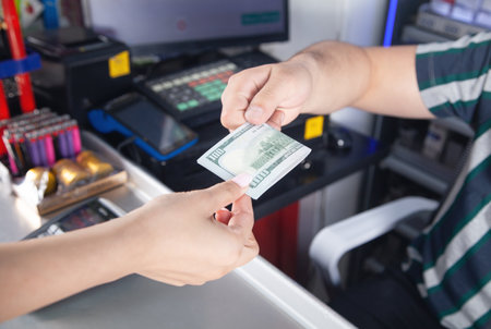 Young woman paying money in the supermarket.