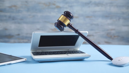 Judge gavel with a computer mouse and laptop.