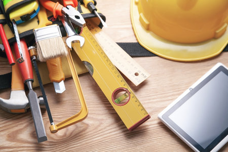 Work tools, helmet with tablet on wooden background.