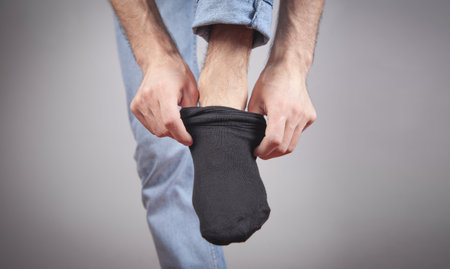Caucasian man wears socks in home.の写真素材