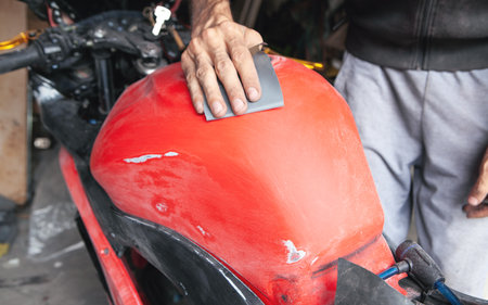 Preparation for painting a motorcycle. Hand in a sandpaperの写真素材