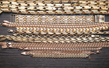 Group of gold jewelry on dark background.